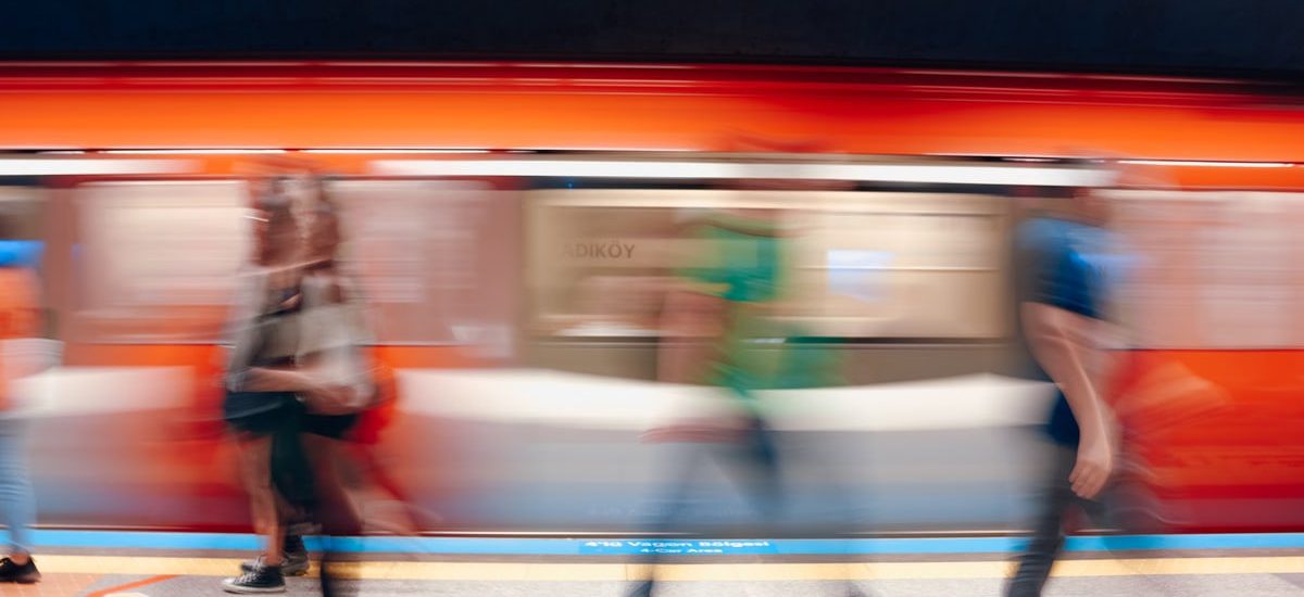 Dynamic scene of commuters in a subway station with motion blur capturing the rush.