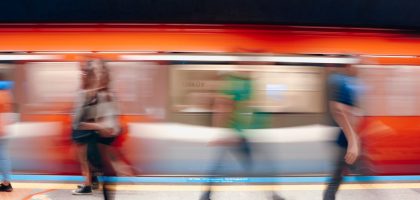 Dynamic scene of commuters in a subway station with motion blur capturing the rush.